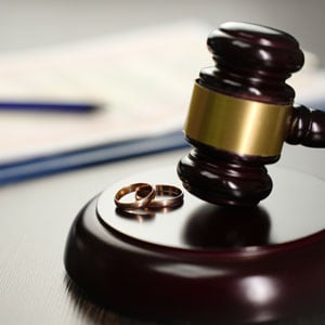 Gavel with two wedding rings on a desk, symbolizing the Divorce Process - Maines Legal